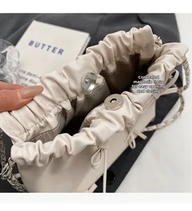 Detail of cream drawstring bucket bag showing internal magnetic closure and lining