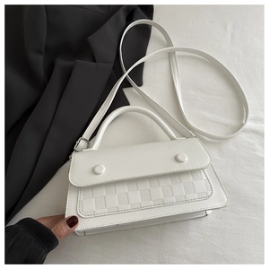Detail of white leather shoulder bag with checkered texture flap and top handle