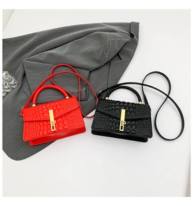 Detail view of red and black faux crocodile leather mini bags with golden metal buckles