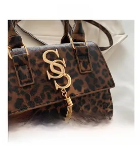 Close-up of leopard print shoulder bag with golden S logo and metallic fringe detail