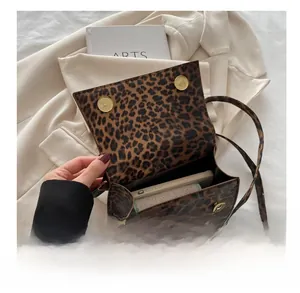 Macro detail of leopard print crossbody bag interior capacity with magnetic snap closure