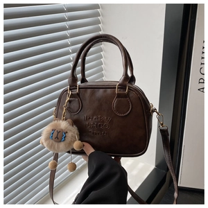 Detail der braunen Vintage-Bowlingtasche mit LHCO Smu-Prägung und Plüsch-Anhänger