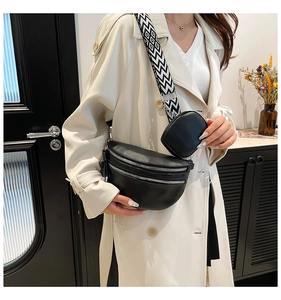 Dettaglio borsa a tracolla in pelle nera con cinturino geometrico e mini astuccio
