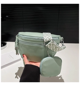 Detail of light green pebbled leather waist bag with geometric wide strap and mini pouch