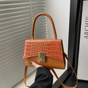 Orangebraune Handtasche aus Lackleder mit Krokoprägung und goldener M-Schnalle