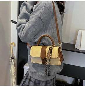 Detalle del bolso de hombro vintage bicolor con colgante decorativo de raqueta de tenis