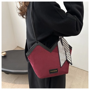 Close-up of wine red velvet tote bag featuring stylish scarf detail and fashion tag