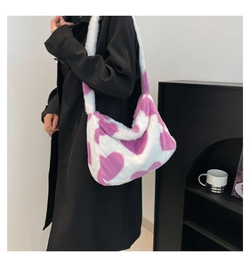 Detail einer Plüschtasche in Weiß mit lila Herzen an der Schulter des Models getragen
