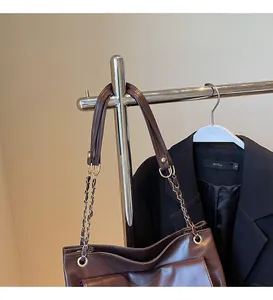 Détail de la bandoulière chaîne sur le grand sac cabas fourre-tout marron foncé