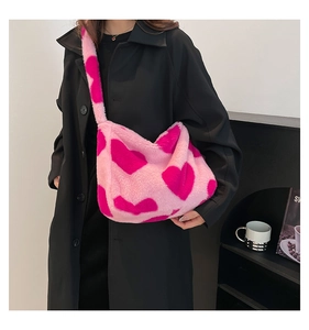 Nahaufnahme der rosa Plüsch-Tragetasche mit Herzmustern auf einer Model-Schulter