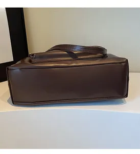 Détail de la base épurée et de la structure latérale de ce grand sac cabas en cuir marron