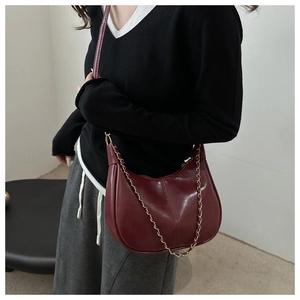 Détail du sac demi-lune en cuir PU bordeaux avec chaîne dorée et bandoulière réglable