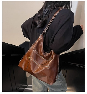 Sac Hobo marron en cuir huilé avec fermetures éclair argentées vue de dos et de côté
