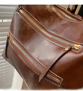 Détails d'un sac porté épaule en similicuir caramel foncé avec fermetures éclair