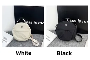 Close-up of black and white round nylon crossbody bags with top handles and adjustable straps