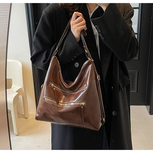 Détail d'un grand sac cabas marron foncé vintage avec des fermetures dorées chic