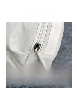Detail of the beige nylon fabric texture and high-quality zipper hardware on a small bag