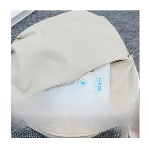 Detail of the front zipper pocket on a beige nylon crossbody bag showing storage capacity