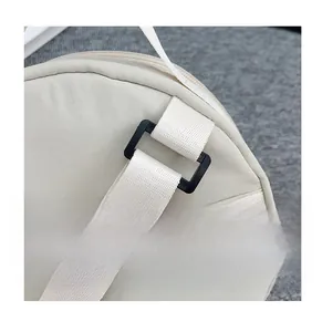 Detail of durable beige nylon fabric bag showing strap connector and plastic buckle