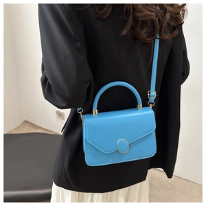 Détail du sac à main bleu en cuir PU avec fermoir doré et coutures pour porté épaule