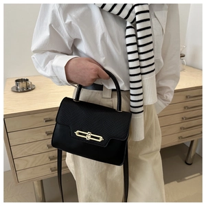 Detail of elegant black leather handbag featuring gold twist lock and plaid texture