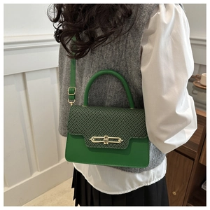 Detail view of green vintage crossbody bag with woven flap and golden metal clasp lock