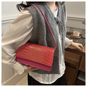 Detail of hot pink crocodile embossed leather on a vintage baguette shoulder bag