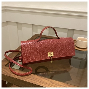 Detail of red woven shoulder bag showing Intrecciato texture and gold metal clasp