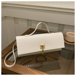 Detailed view of white woven texture baguette bag with golden buckle and chain accent