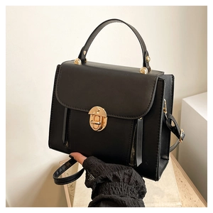 Détail du sac à main noir élégant avec fermoir doré et fermetures éclair décoratives