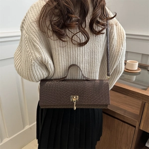 Brown crocodile pattern baguette bag with gold buckle worn with casual autumn outfit