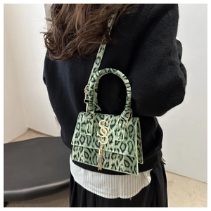 Detail of green leopard print handbag with gold SS logo and elegant metal tassel