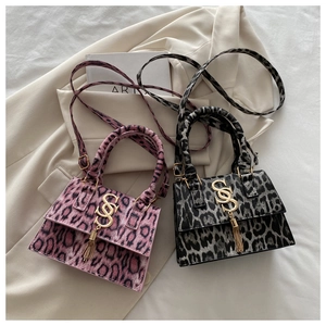 Detail of leopard and spotted fur texture on pink and black crossbody bags with gold SSS logo