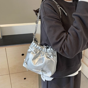 Silver metallic drawstring bucket bag with bow accents and chain strap for women