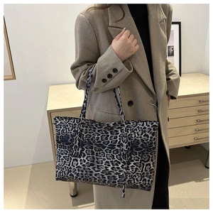 Close-up of stylish leopard print tote bag showing fine texture and long shoulder straps