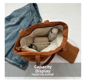 Detail view of large corduroy tote bag showing interior capacity with wallet and umbrella