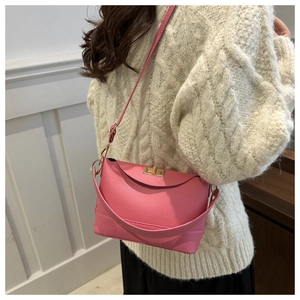 Detailed macro shot of rose pink lychee leather bag with iconic silver metal twist lock