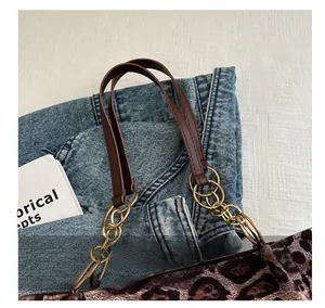 Detail of leopard print tote bag featuring brown leather handle and gold chain link