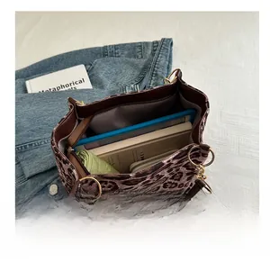 Spacious interior of leopard print tote bag showing storage for tablet and books