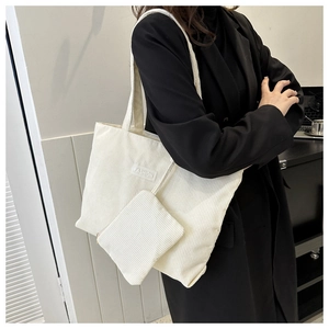 Detailed texture of white corduroy tote bag and matching clutch with Fashion label