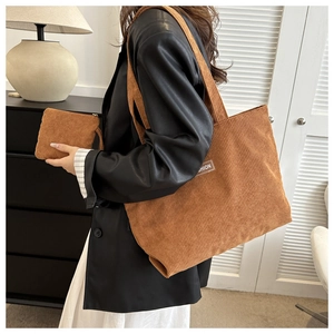 Close-up of caramel brown corduroy tote bag with fashion label and matching small pouch