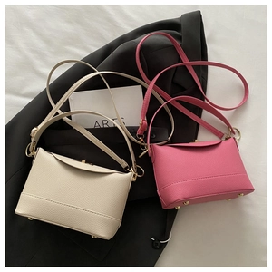 Detail of lychee pattern leather bags with golden twist locks and metal studs
