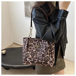 Detail of leopard print tote bag with gold chain strap and brand leather plaque