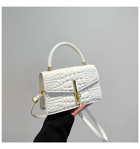 Macro detail of white crocodile embossed leather texture with golden metal hardware