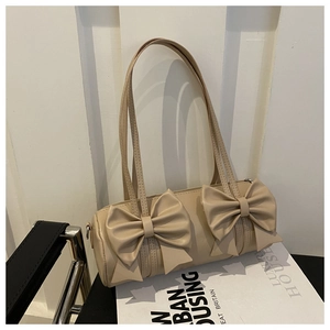 Primer plano de bolso cilíndrico beige con diseño de doble lazo y detalle de cremallera
