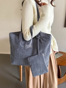 Large gray corduroy tote bag with stripes and matching pouch shown on a model