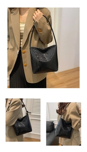 Detail of glossy black crocodile texture on a large capacity tote bag for office wear