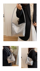 Detailed macro view of silver crocodile pattern texture on a sleek bucket shoulder bag
