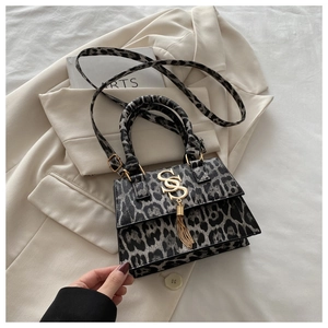 Macro detail of leopard print handbag with golden SS logo and elegant long tassels