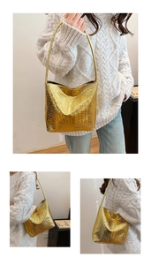 Detail of golden hobo bag with crocodile embossed texture and metallic finish